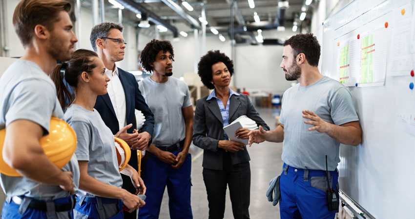 group of diverse workers holding hard hats during job meeting