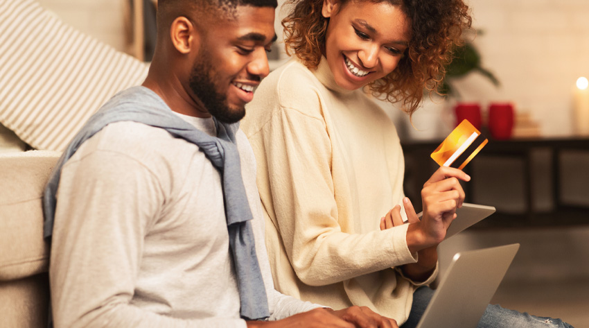 couple online shopping holding credit card