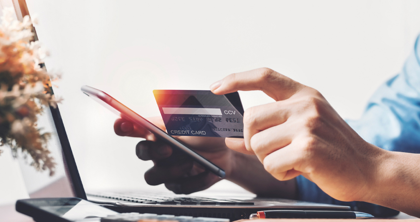 man looking at credit card and cell phone